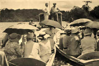 Passengers in rowing boats being towed by launch